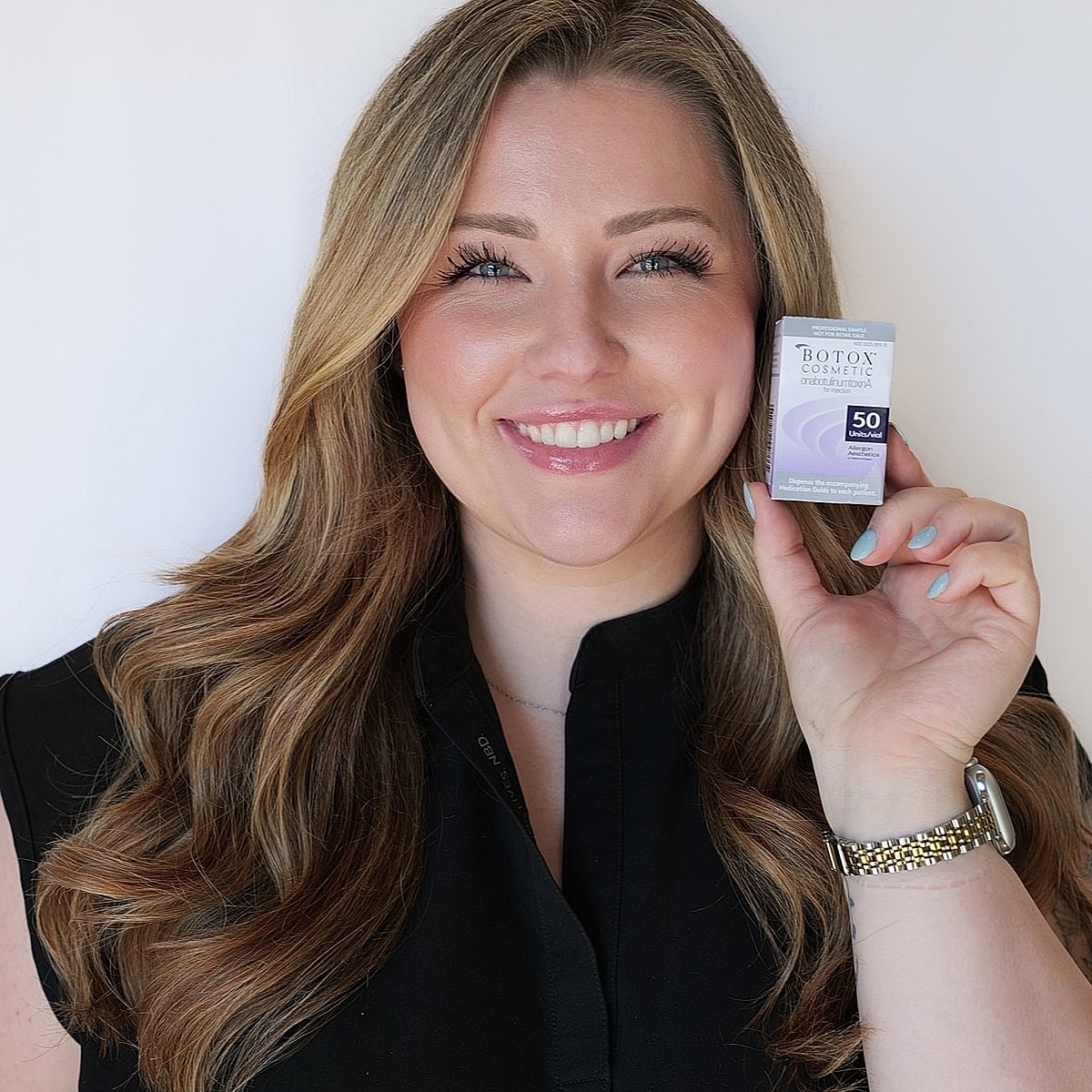 Woman holding Botox Cosmetic product, smiling brightly.
