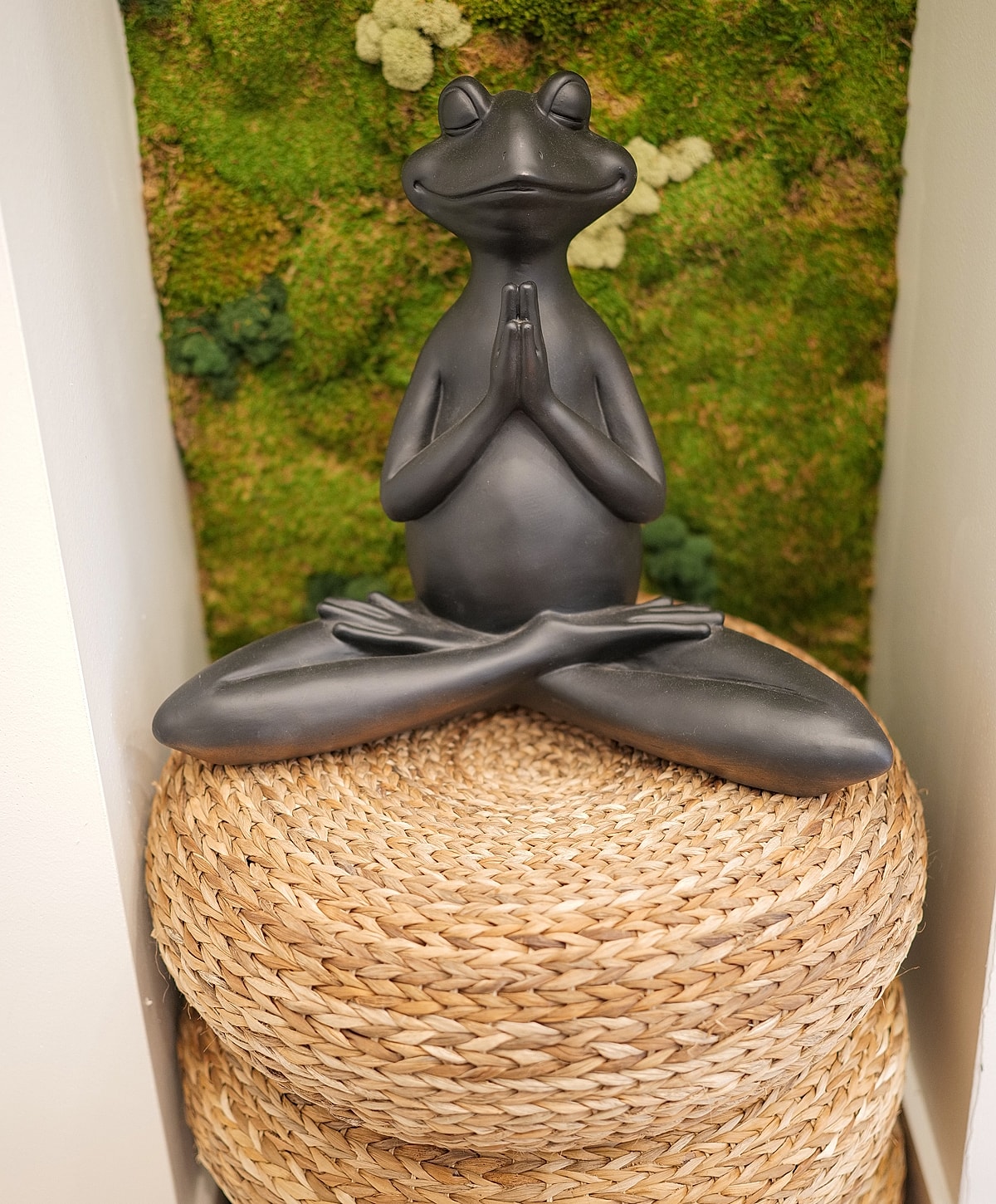 Meditating frog sculpture on wicker stool