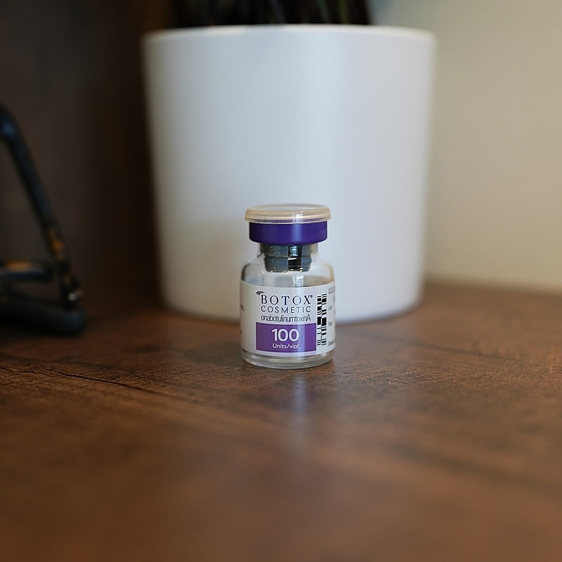 Botox cosmetic vial on a wooden surface.