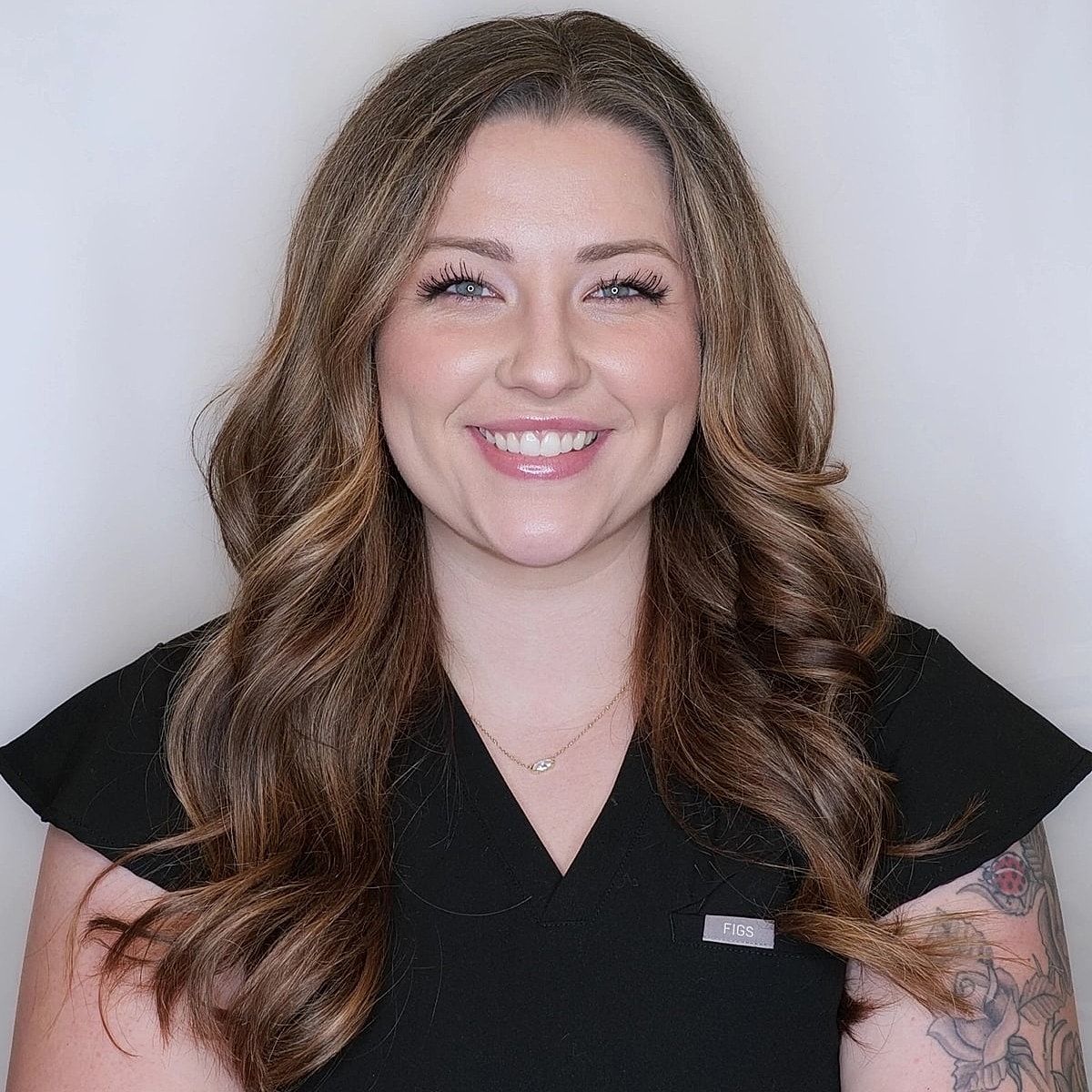 Smiling woman in professional attire against white backdrop.