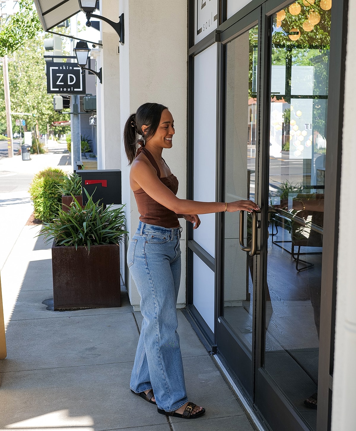 Woman opening door to a salon or store.