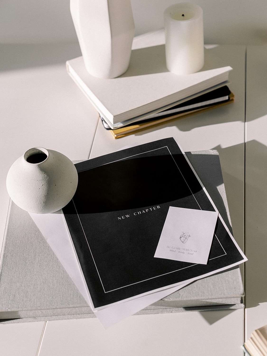 Vase and papers on a minimalist table.