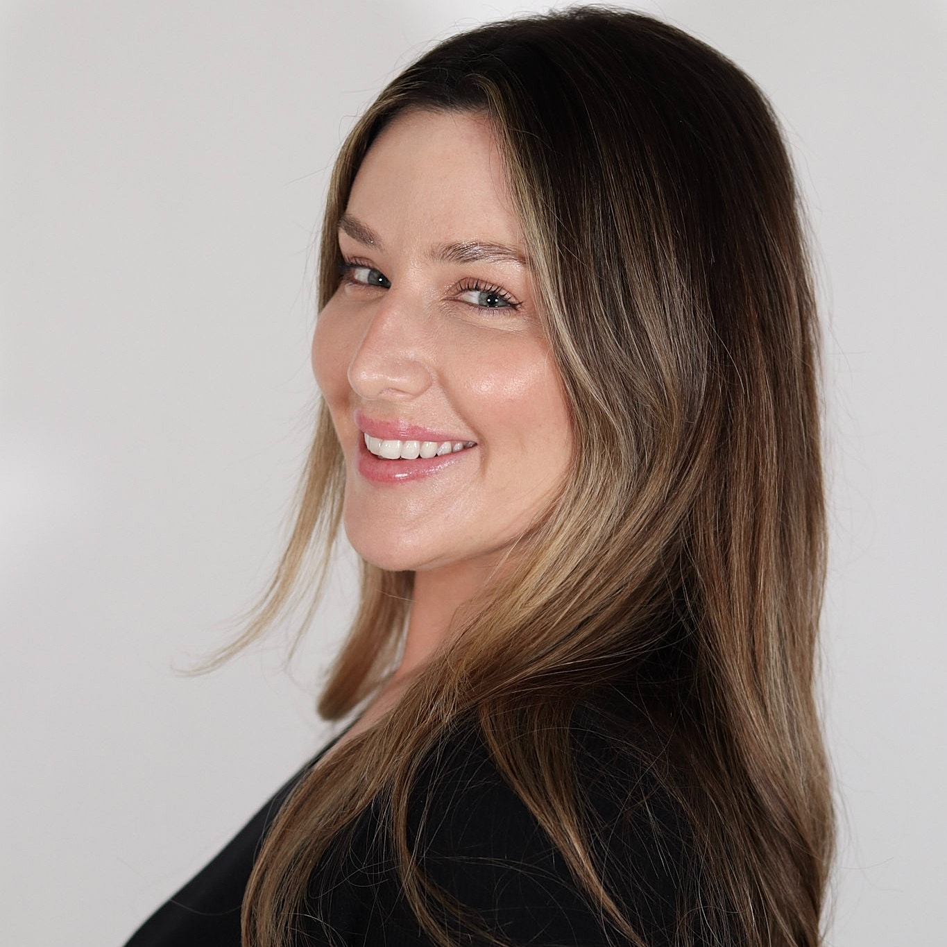 Smiling woman with long hair, side profile.