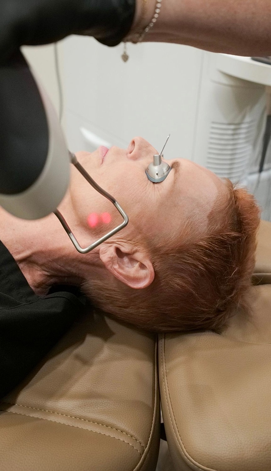 Woman receiving a facial treatment in a clinic.