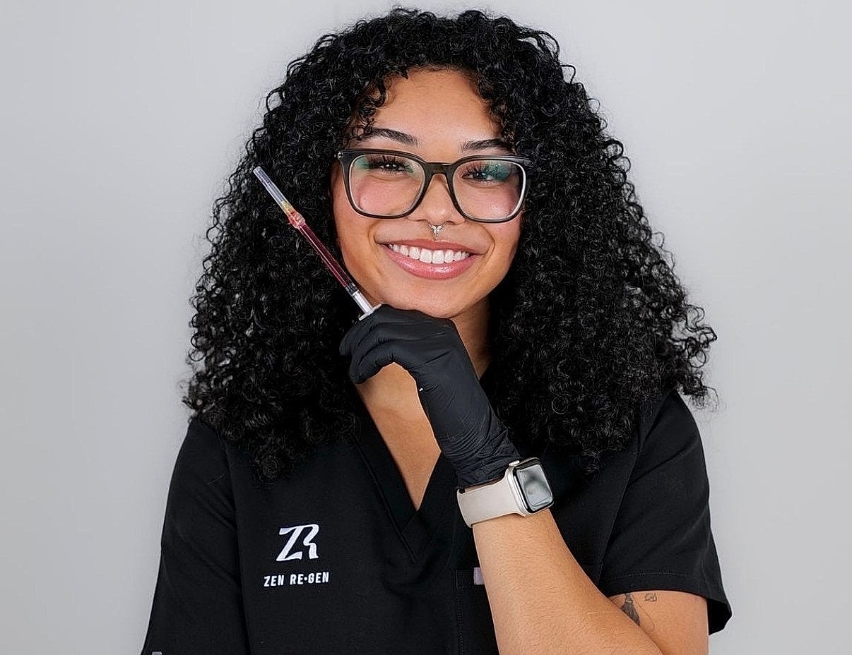 Smiling professional holding syringe in a clinic.
