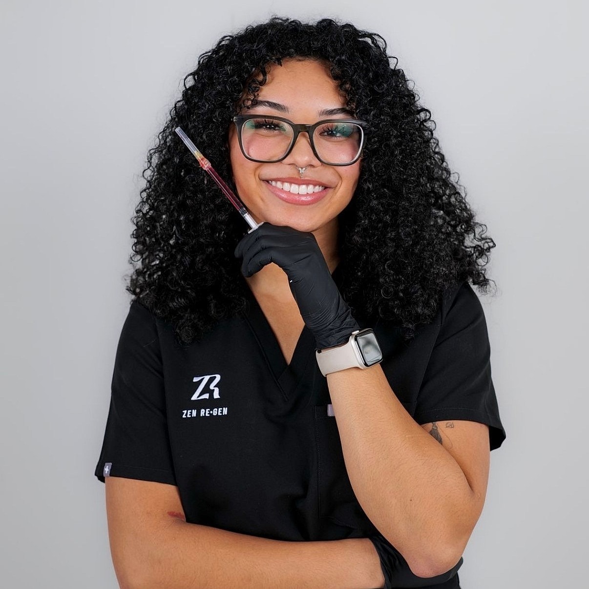 Smiling professional holding a syringe in gloves.