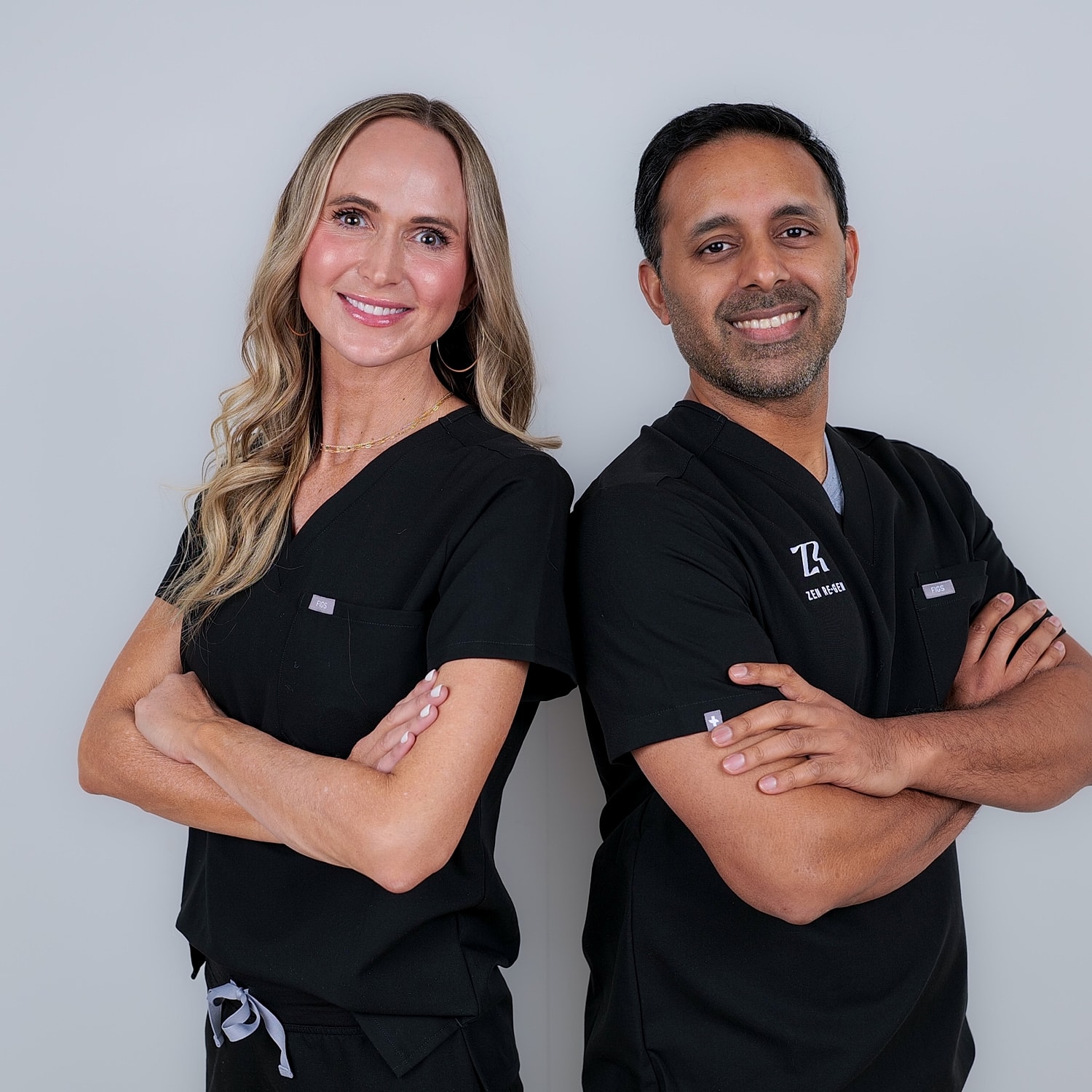 Smiling medical spa professionals in black scrubs.