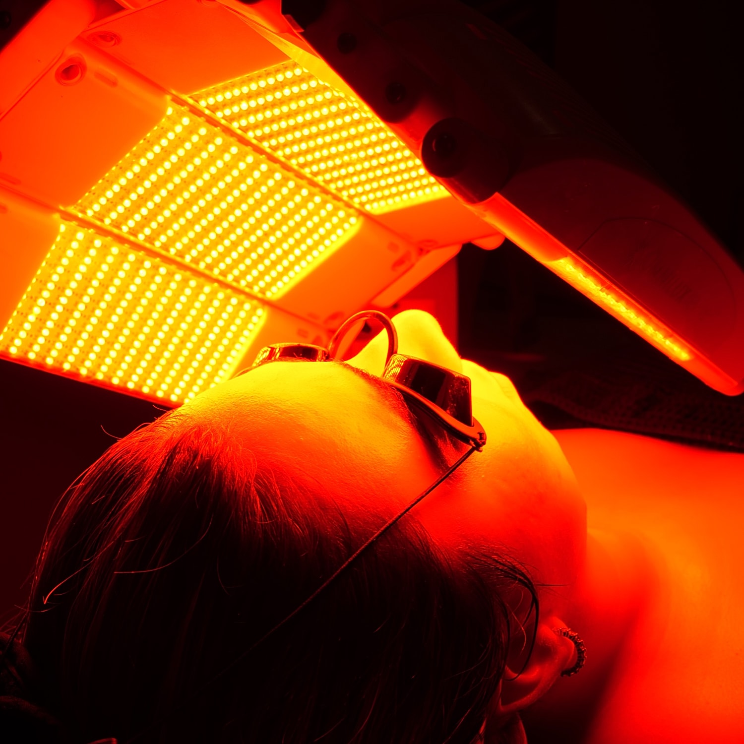 Person receiving red light therapy treatment.