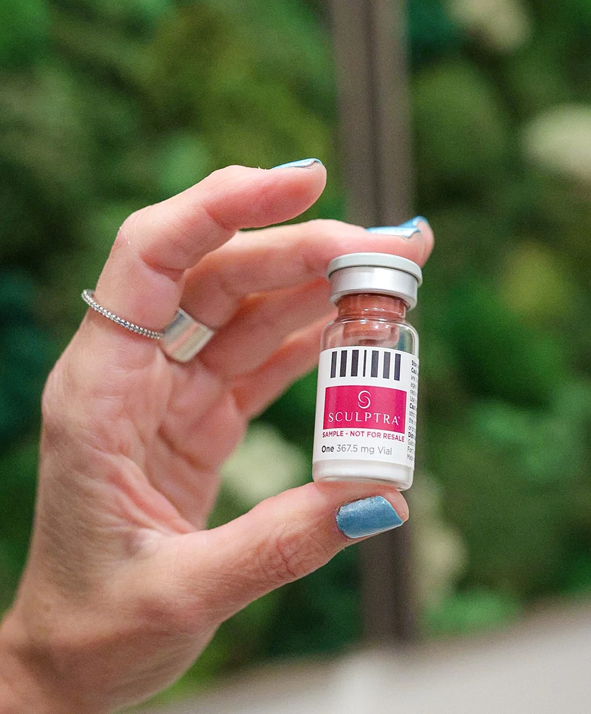Sculptra vial held in hand, sample only.
