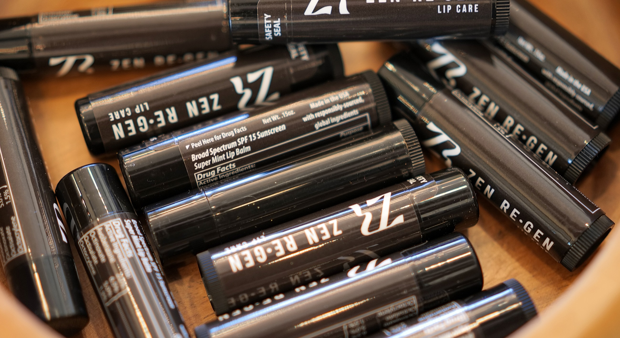 Assorted lip care products in a wooden bowl.