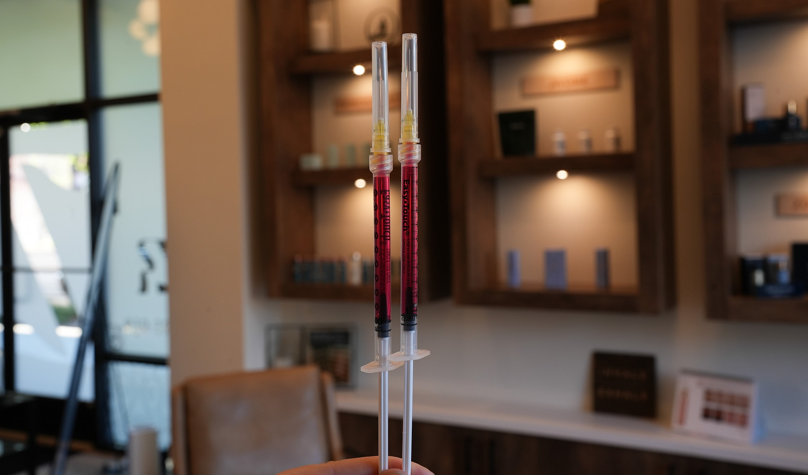 Two syringes filled with colored substances.