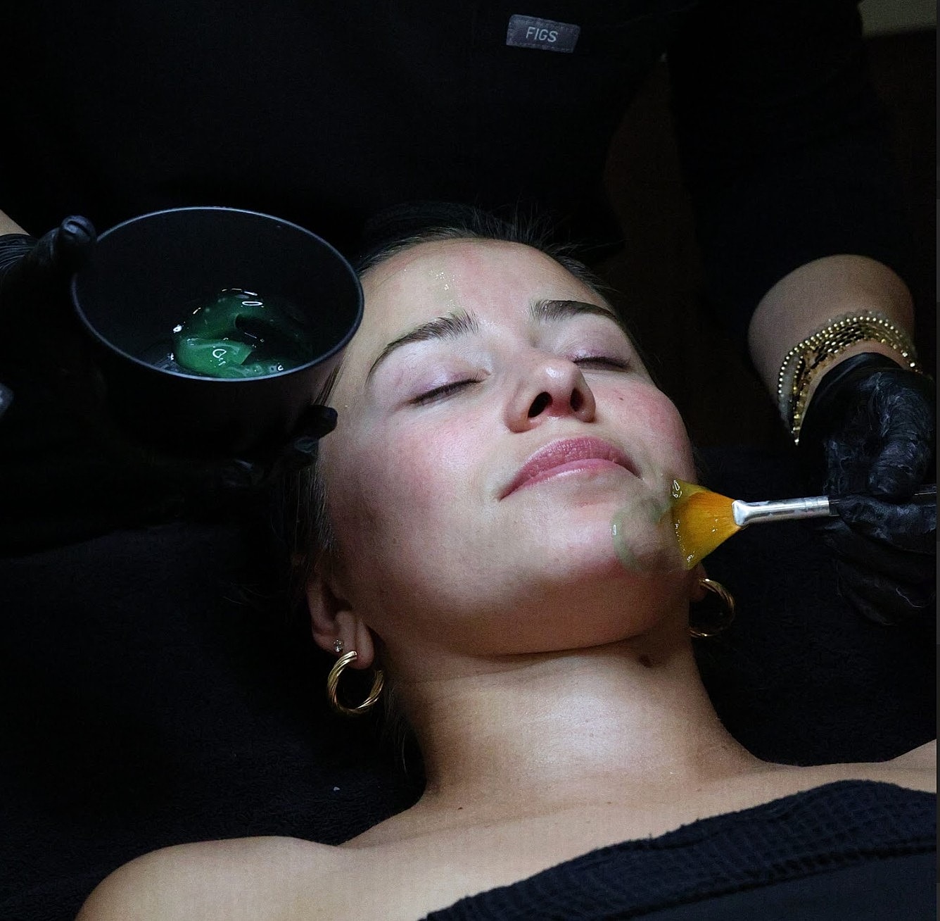 Facial treatment in progress with green gel.