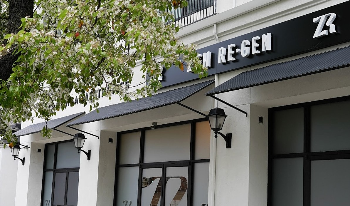 Building exterior with sign and greenery.