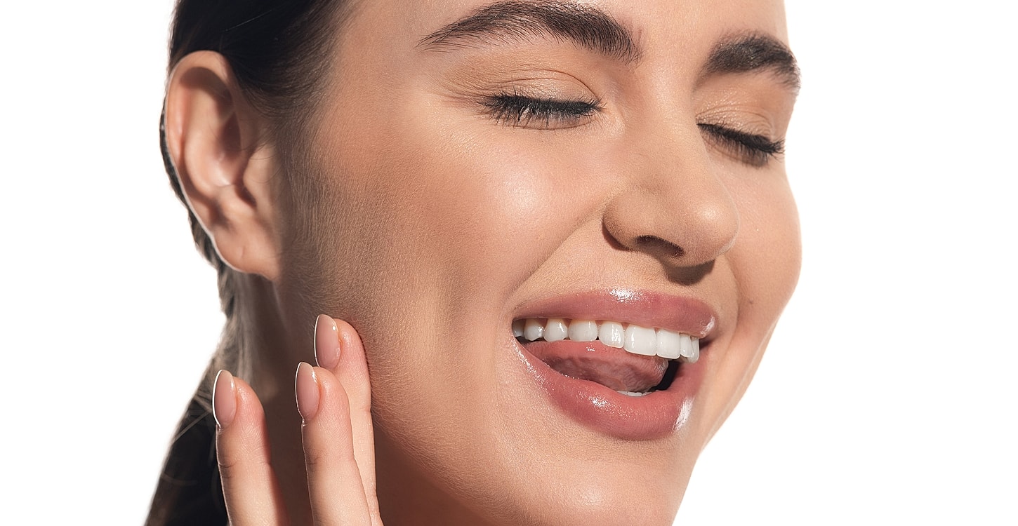 Smiling woman with soft, glossy skin.